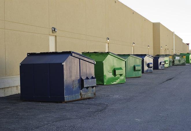 a forklift lifts a full dumpster from a work area in Austell GA